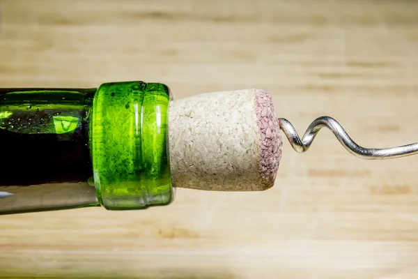 Corkscrew and Cork from wine on a wooden surface — Stock Photo, Image