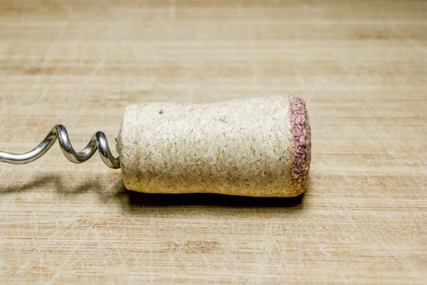 Corkscrew and Cork from wine on a wooden surface — Stock Photo, Image