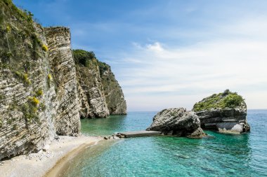 Plaj ve uçuruma Budva'nın St. Nicholas Adası üzerinde,