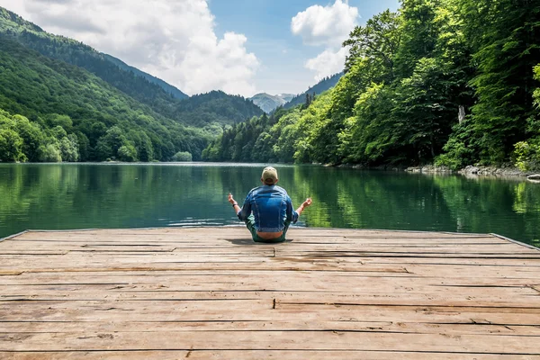 The man meditating in lotus position on Biogradsko lake in the n — Stock Photo, Image