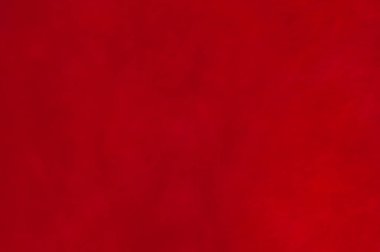 Kırmızı doku. Süet kumaşın kırmızı mat arka planı, yakın plan. Pürüzsüz deri kadife desenli. Keçeli kumaş makro