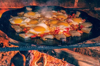 Tavada ateşte çırpılmış yumurta, açık ateşte pişmiş yumurta. Yumurtalar ateşte kızarır..