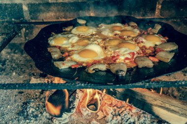 Tavada ateşte çırpılmış yumurta, açık ateşte pişmiş yumurta. Yumurtalar ateşte kızarır..