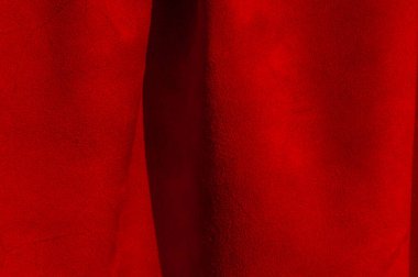 Süet kumaşın kırmızı mat arka planı, yakın plan. Pürüzsüz deri kadife desenli. Keçeleşmiş makro. Kırmızı süet kumaş. Kumaş, deri, tasarımcılar için malzeme..