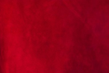 Süet kumaşın kırmızı mat arka planı, yakın plan. Pürüzsüz deri kadife desenli. Keçeleşmiş makro. Kırmızı süet kumaş. Kumaş, deri, tasarımcılar için malzeme..