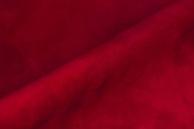 Süet kumaşın kırmızı mat arka planı, yakın plan. Pürüzsüz deri kadife desenli. Keçeleşmiş makro. Kırmızı süet kumaş. Kumaş, deri, tasarımcılar için malzeme..