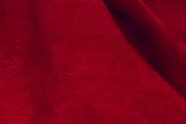 Süet kumaşın kırmızı mat arka planı, yakın plan. Pürüzsüz deri kadife desenli. Keçeleşmiş makro. Kırmızı süet kumaş. Kumaş, deri, tasarımcılar için malzeme..