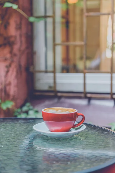 red coffee cup. Red Coffee cup in the garden. Coffee latte art in a red cup. Red cup of latte art. Morning coffee.