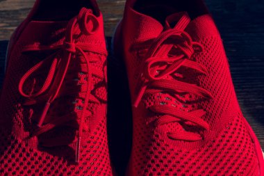 Kırmızı renkli yeni spor ayakkabılar. Kırmızı spor ayakkabılar. Ahşap arka planda bir çift kırmızı spor ayakkabı. Spor ayakkabılar.