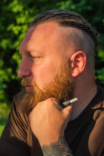 Hippi tarzı sakallı adam. Çekici adam, uzun saçlı, Avrupalı görünümlü, sakallı. Kahverengi tişörtlü adam. Ormandaki adam.