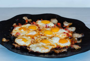 Yumurtalar sokakta ateşte kızarır. Pastırmalı sahanda yumurta. Fırındaki şenlik ateşinde bir tabak yumurta. Sokak yemeği. Yiyeceklerle dinlen. Tavada ızgara yumurta.