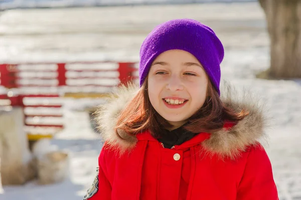 小女孩穿着漂亮的温暖的红色衣服在外面雪地里玩耍 冬天穿红色夹克的女孩在街上 一个9岁或10岁的学龄女孩 — 图库照片