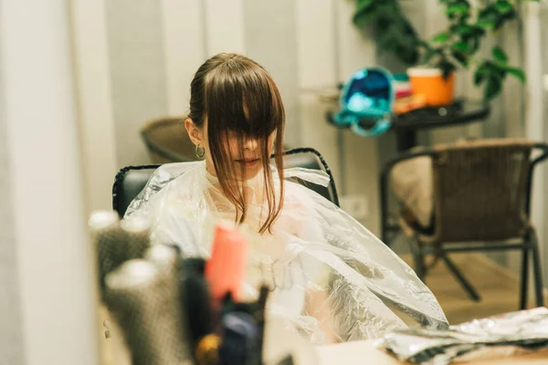 可愛い女の子にヘアスタイルを作る美容師 10代の少女が美容室で前髪を照らしています オレンジの前髪 明るい髪の傾向 — ストック写真