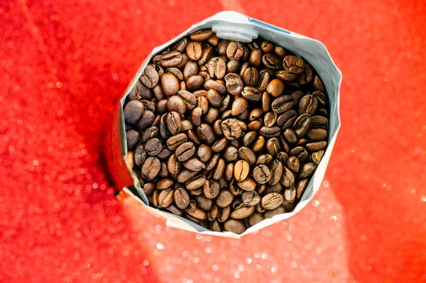 Gold foil coffee bean bag isolated on red background. Coffee, cheerfulness, aroma