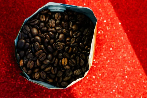 Gold foil coffee bean bag isolated on red background. Coffee, cheerfulness, aroma