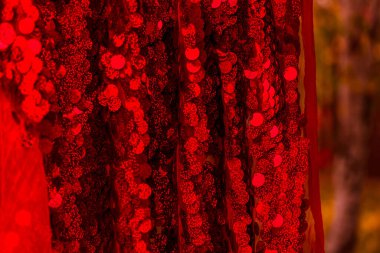 Kırmızı pullar. Pırıl pırıl pullar. Arka plan için kırmızı pullu kumaş. dikdörtgen kırmızı, pullu parlak kumaş, Noel arkaplanı. Dokuma sekansları, kırmızı boncuklar. Moda Kumaşı