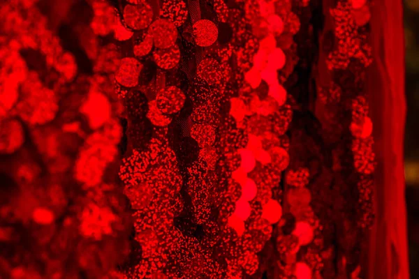 Kırmızı pullar. Pırıl pırıl pullar. Arka plan için kırmızı pullu kumaş. dikdörtgen kırmızı, pullu parlak kumaş, Noel arkaplanı. Dokuma sekansları, kırmızı boncuklar. Moda Kumaşı