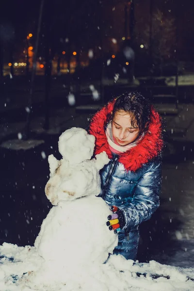 Χαρούμενο Κορίτσι Που Πλέκει Έναν Χιονάνθρωπο Μια Χιονισμένη Χειμερινή Βόλτα — Φωτογραφία Αρχείου