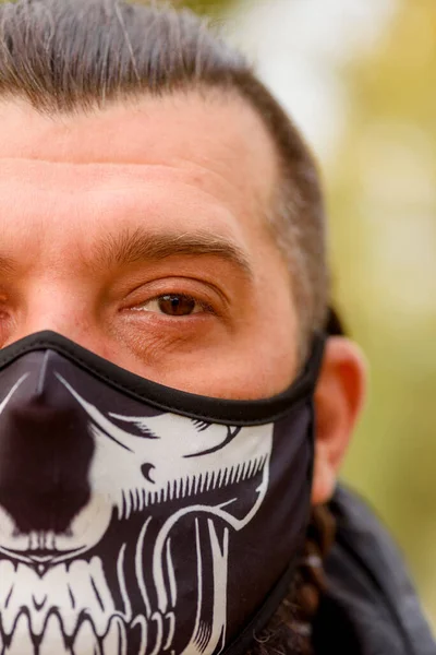 man in winter clothes on the street with a medical face mask on. Closeup male in a respirator to protect against infection with influenza virus or coronavirus. Man in a protective mask on the street