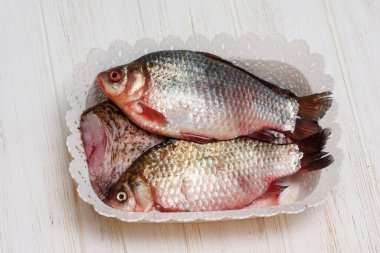 Taze balık. Beyaz ahşap arka planda çiğ balık. Masadaki beyaz ahşap mutfak tahtasındaki balıklar