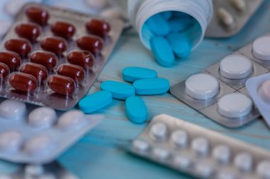 Mavi arka planda haplar, haplar ve kapsüller. İlaç ve sağlık. Mavi arka planda haplar.