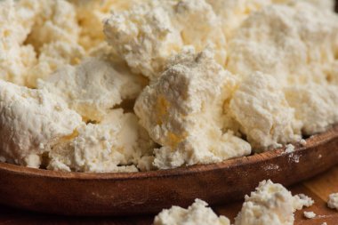 Kırsal ahşap tabakta süzme peynir. Ahşap tabakta süzme peynir. Mayalanmış süt sağlıklı yiyecek