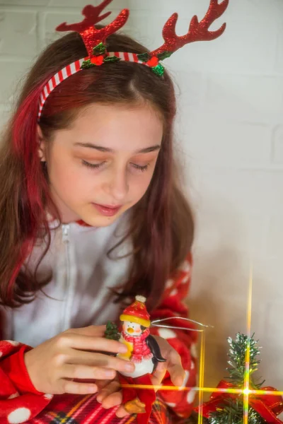 Portret Van Gelukkig Meisje Kijkend Naar Decoratieve Speelgoedbal Bij Kerstboom — Stockfoto