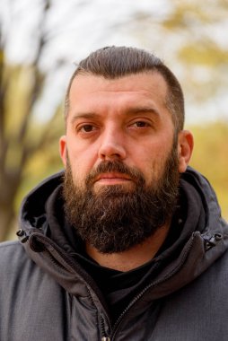 Sokakta gri ceketli sakallı bir adam. Bir adamın portresi. Sakallı adam..