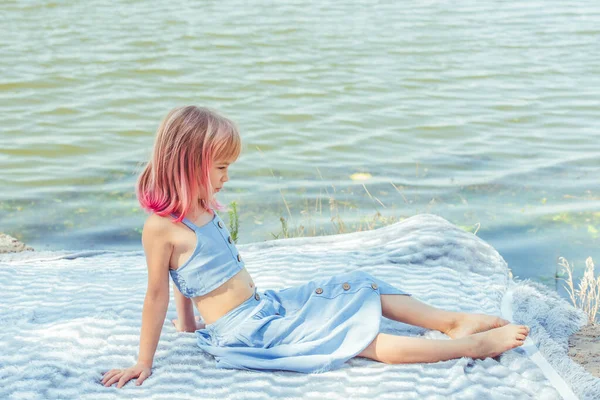 Kız portresi. Yaz gününde küçük şirin bir kızın açık hava portresi. Pembe saçlı kız. Çocuk 7-8