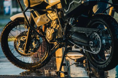 Motosiklet yıkama serisi. Gün batımında oto yıkamada motosiklet yıkamak..