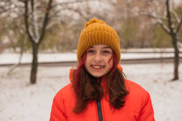 明るいオレンジの暖かいジャケットの女の子 雪の日にオレンジのジャケットの女の子 冬の十代の女の子 — ストック写真