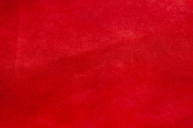 Süet kumaşın kırmızı mat arka planı, yakın plan. Pürüzsüz deri kadife desenli. Keçeli kumaş