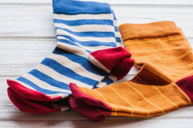 Ahşap arka planda örülmüş çizgili çoraplar. Ev yapımı tekstil ürünleri. Çorap, örgü