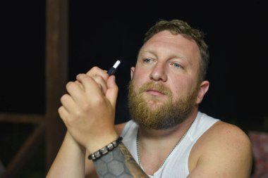 Tüylü sakallı, havalı kızıl saçlı hippi adamın yakın portresi. Kızıl adam.