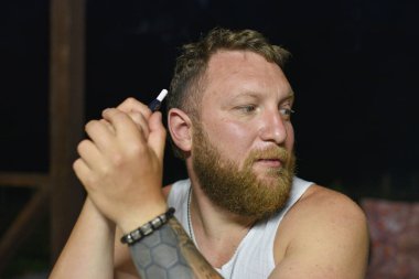 Tüylü sakallı, havalı kızıl saçlı hippi adamın yakın portresi. Kızıl adam.