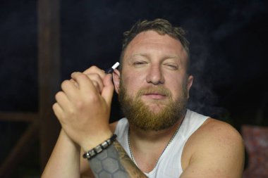 Tüylü sakallı, havalı kızıl saçlı hippi adamın yakın portresi. Kızıl adam.