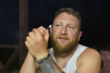 Tüylü sakallı, havalı kızıl saçlı hippi adamın yakın portresi. Kızıl adam.