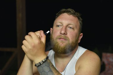 Tüylü sakallı, havalı kızıl saçlı hippi adamın yakın portresi. Kızıl adam.