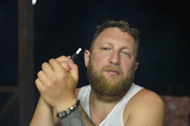 Tüylü sakallı, havalı kızıl saçlı hippi adamın yakın portresi. Kızıl adam.