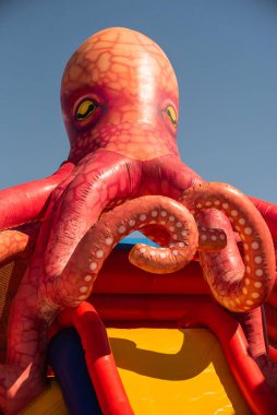 Yazın plajda şişme su kaydırağı. Şişirilebilir su parkı cazibesi