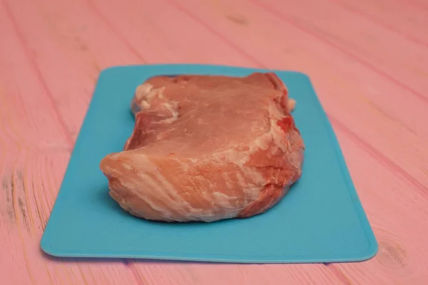 Розовые Сырые Свиные Стейки Лежат Синей Доске Аппетитное Мясо Свинина — стоковое фото