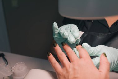 Manikürcüde bir kadın güzellik uzmanından manikür alıyor. Güzellik tedavisi konsepti. Manikür süreci