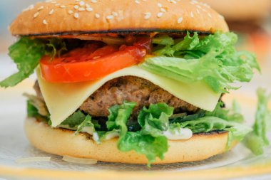 Hamburger pişirmek, hamburger yapmak, çöreklerle resimler, çiğ et, peynir ve sebzeler.