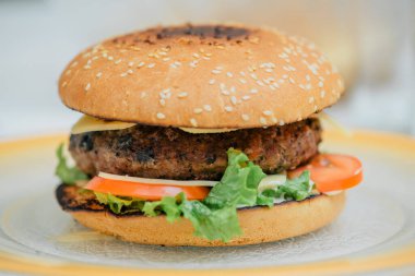 Hamburger pişirmek, hamburger yapmak, çöreklerle resimler, çiğ et, peynir ve sebzeler.