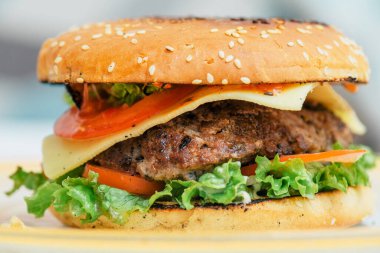 Hamburger pişirmek, hamburger yapmak, çöreklerle resimler, çiğ et, peynir ve sebzeler.