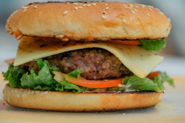 Hamburger pişirmek, hamburger yapmak, çöreklerle resimler, çiğ et, peynir ve sebzeler.