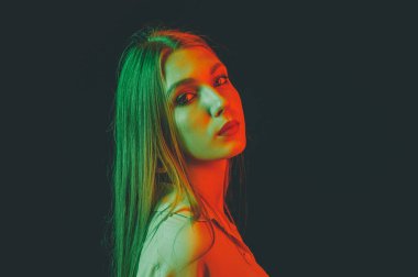 Güzel bir kadın modelin yaratıcı portresi. Stüdyoda turuncu ve yeşil ışık.