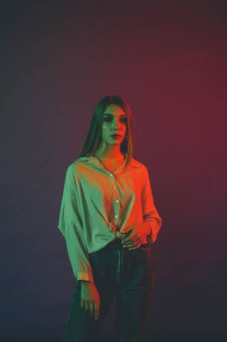 Güzel bir kadın modelin yaratıcı portresi. Stüdyoda turuncu ve yeşil ışık.