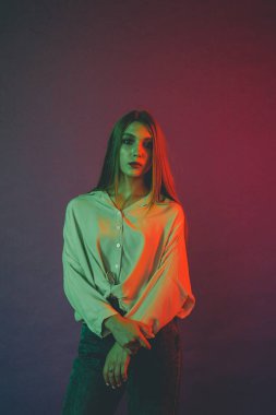 Güzel bir kadın modelin yaratıcı portresi. Stüdyoda turuncu ve yeşil ışık.