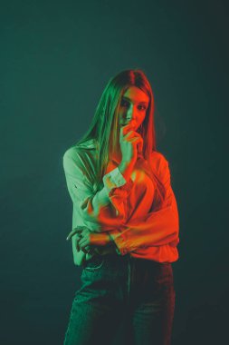 Güzel bir kadın modelin yaratıcı portresi. Stüdyoda turuncu ve yeşil ışık.